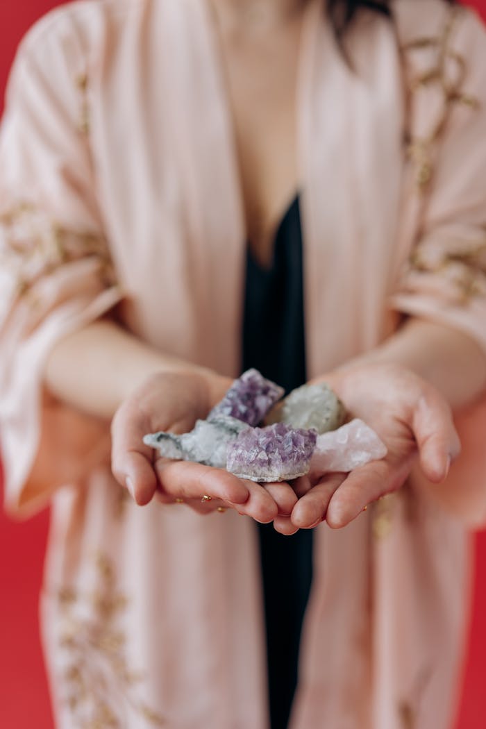 A woman gently holds healing crystals in her hands, focusing on positive energy and mindfulness.